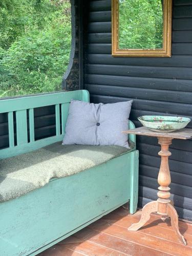 a blue bench with a bowl on a table on a porch at Cozy Summer House In Rørvig With Historical Charm in Rørvig