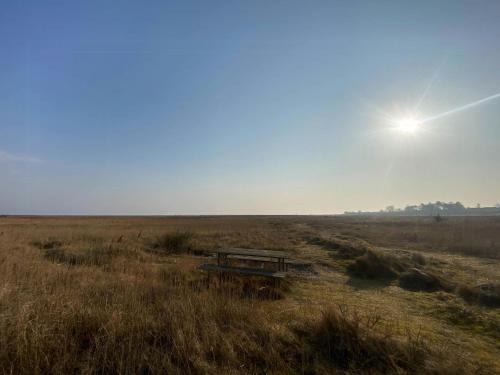a picnic table in the middle of a field at Beach House With Sauna By Norsminde Harbour in Malling