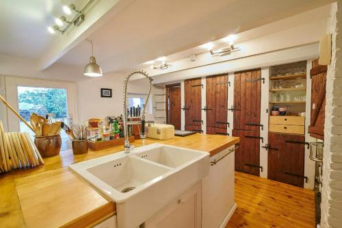 una cucina con lavello bianco e armadi in legno di Charming Country House In Schleswig-Holstein a Fedderingen