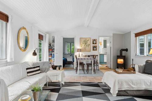 ein Wohnzimmer mit einer weißen Couch und einem Tisch in der Unterkunft Cozy Holiday Home Near The Beach And Nature in Frederiksværk