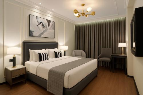 a hotel room with a bed and a chair at Aauris in Kolkata
