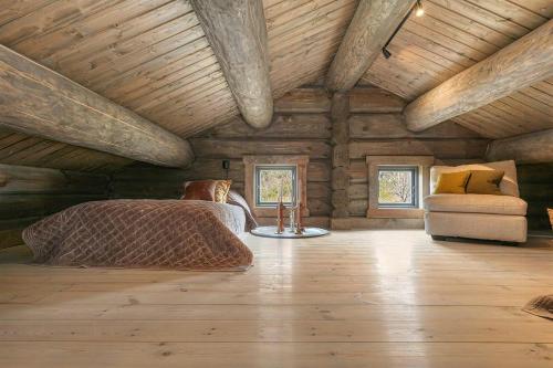 a room with a bed and a chair in a wooden cabin at Cabin With Panoramic View Over Hardangervidda in Dagali