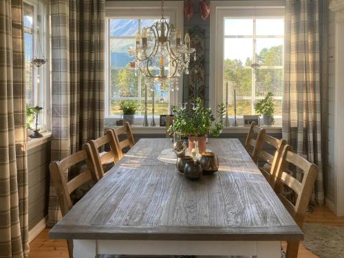 a dining room with a wooden table and a chandelier at Log Cabin By Skoddeberg Lake In Tjeldsund in Grovfjord