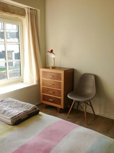 - une chambre avec un lit, une chaise et une commode dans l'établissement Basque Cottage With Views Of La Rhune Mountain, à Arcangues