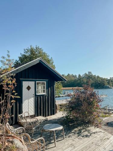 a small shack with chairs and a table on a dock at Idyllic Island House With Pool in Svartsö