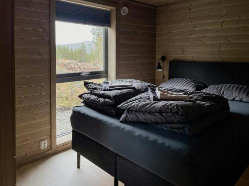 a bed with pillows on it in a room with a window at Modern Cabin With Panoramic View On Bringsfjellet in Lalm