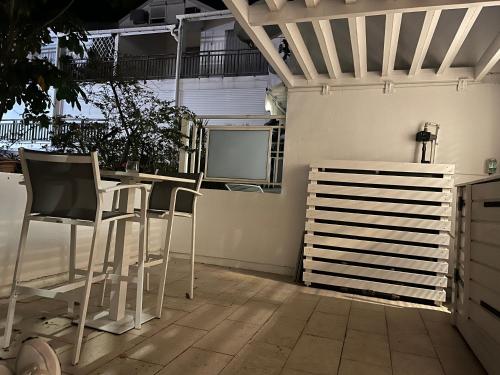 a patio with chairs and a table and a television at YATCH view II in Pointe-à-Pitre