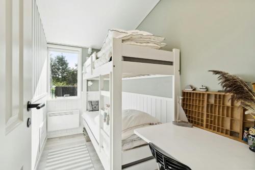 Ce lit superposé blanc se trouve dans un dortoir doté d'une fenêtre. dans l'établissement Classic Seaside Hotel Feel In Ringkøbing Fjord, à Hemmet