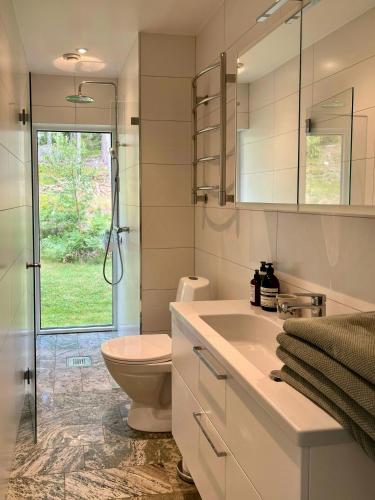 a bathroom with a toilet and a sink and a shower at Your Archipelago Dream On Ingarö in Värmdö