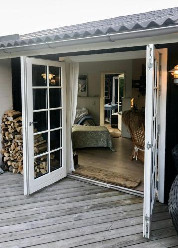 a patio with a door open to a room at Beach-Close Wooden Summer House In Tversted in Tversted