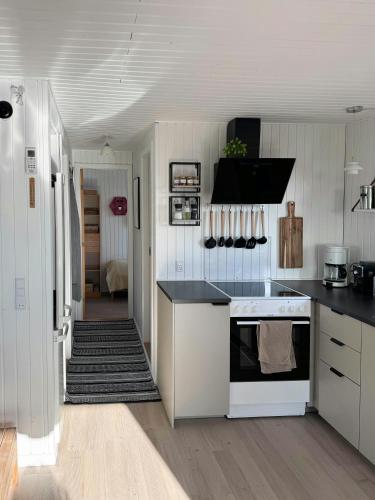 a kitchen with white cabinets and a black counter top at Seaside Cottage With Ocean View At Flovt Beach in Haderslev