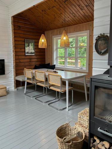 a dining room with a table and chairs and a tv at Fine Details In Forest Setting In Ebeltoft in Ebeltoft