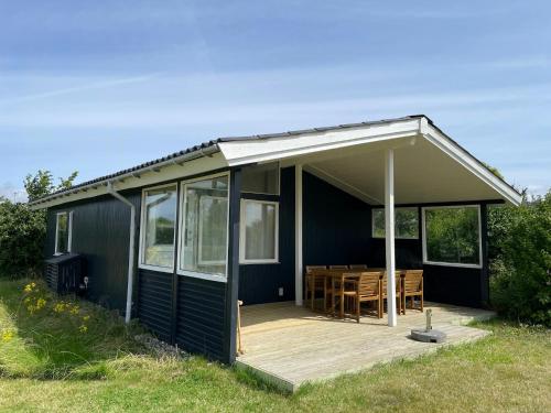 een zwart huis met een terras en een tafel bij Home With Nordic Interior in Korsør
