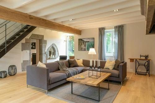 ein Wohnzimmer mit Sofa und Tisch in der Unterkunft Renovated Stone House In Normandy in Sourdeval-les-Bois