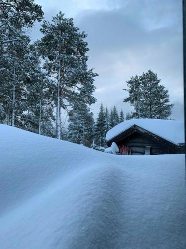 a snow covered cabin with a pile of snow on top at Countryside Cabin With Jacuzzi Near Stryn in Sølberg