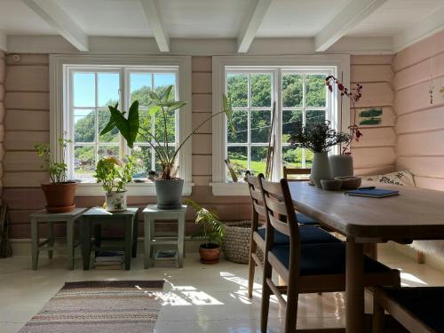comedor con mesa y macetas en Idyllic Farmhouse From 1840 With Sea View In Spind, en Farsund