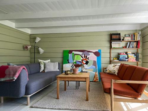 una sala de estar con un sofá y una mesa en Idyllic Farmhouse From 1840 With Sea View In Spind, en Farsund