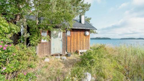 a small wooden house next to a body of water at Cabin On Private Island In Stockholms Archipelago in Mörkö