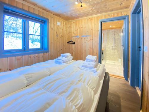 a large bed in a room with a window at Fantastisk Familiehytte Nær Geilo in Geilo