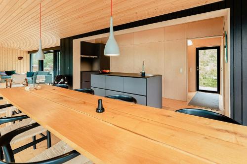 a large wooden table in a room with chairs at Modern Architectural Gem By The Lake In Immeln in Immeln