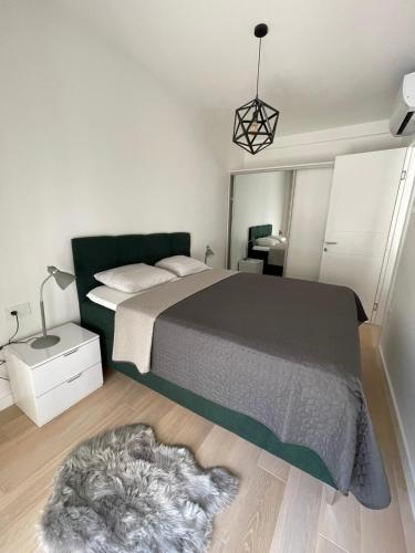 a bedroom with a large bed and a rug at Apartman Agave in Trebinje