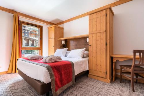 une chambre avec un lit avec une couverture rouge dans l'établissement Résidence Les Arcs 1950 Le Village - maeva Home - Appartement 3 Pièces 6 Personnes - Prestige MAE-6704, à Bourg-Saint-Maurice
