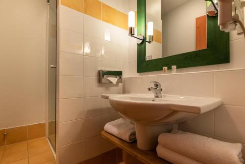 une salle de bain avec un lavabo et un miroir dans l'établissement Résidence Les Arcs 1950 Le Village - maeva Home - Appartement 3 Pièces 6 Personnes - Prestige MAE-6704, à Bourg-Saint-Maurice