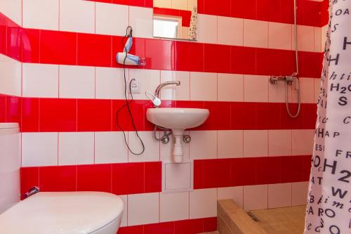 baño rojo y blanco con aseo y lavamanos en Economy Apartment on Krehivska 7, en Leópolis