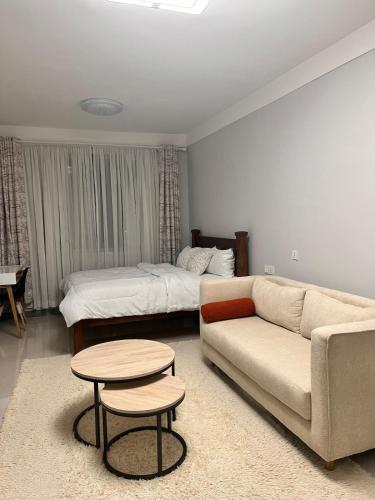a living room with a couch and a bed at The City escape Sabaki green estate - 15 minutes to JKIA and SGR in Marimbeti