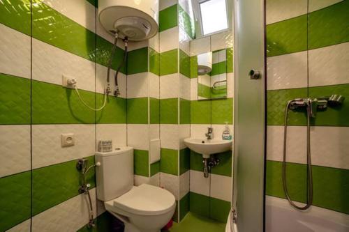リヴィウにあるApartments on Roppoporta 7bの緑と白のバスルーム(トイレ、洗面台付)