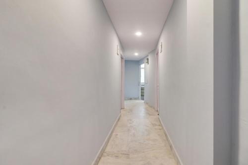 an empty hallway with white walls and a floor at Hotel O Blue moon in New Delhi