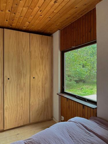 HøjbyにあるAuthentic 60'S Summer House By Ellinge Lyngのベッドルーム(大きな窓、ベッド付)