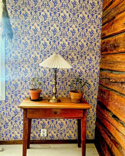 a table with a lamp and two potted plants on it at 19Th Century House With Antiques In Rural Setting in Sandared