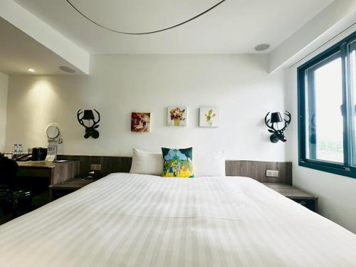 a bedroom with a large white bed and a window at Norway Forest Travel hotel 1 Taichung in Taichung