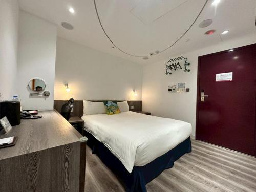 a bedroom with a bed and a red door at Norway Forest Travel hotel 1 Taichung in Taichung