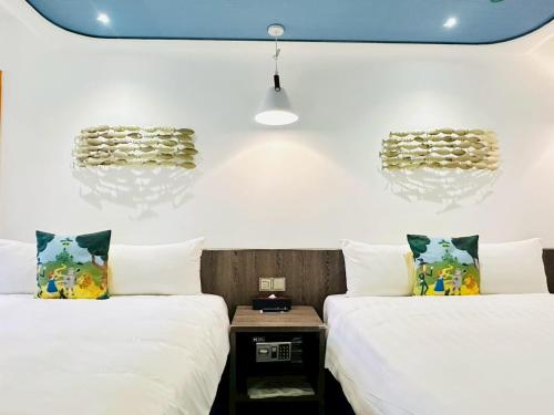 two beds in a room with white walls at Norway Forest Travel hotel 1 Taichung in Taichung