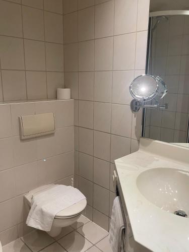 a white bathroom with a toilet and a sink at Gästehaus Wild Nürnberg-West in Oberasbach