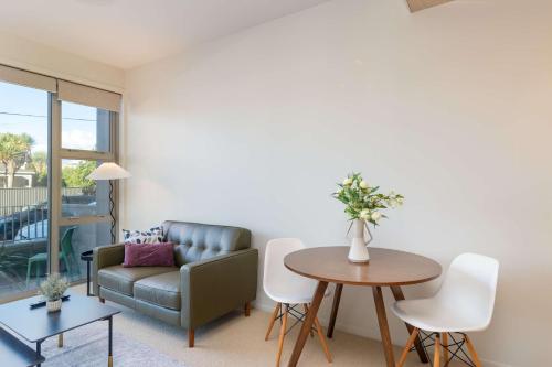 a living room with a couch and a table at Petone Studio - Balcony Bath Tub Sleeps 2 in Lower Hutt