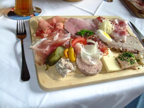 a plate of food on a table with a fork at Gasthof Pisl in Krumpendorf am Wörthersee