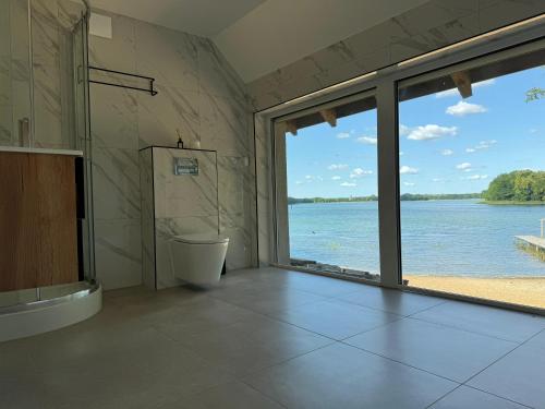 a bathroom with a view of the water at Glamping "Letnisko WISOLA" in Ciemnik