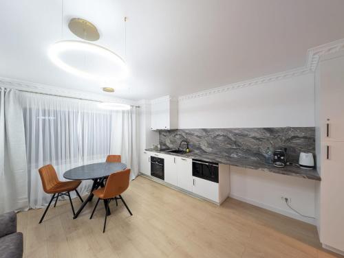 a kitchen and dining room with a table and chairs at Imedio Coral Apartment Aviatiei in Bucharest