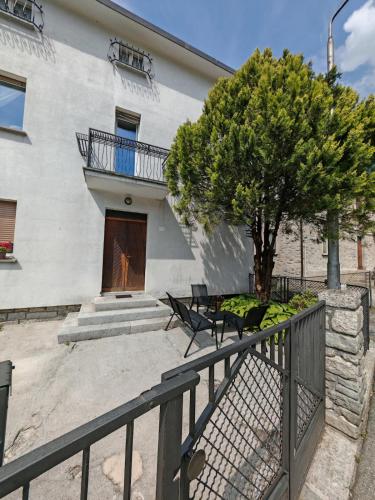 a house with a balcony and a table and a tree at "Casa Lucchinetti" full apartment in Piuro in Prosto di Piuro