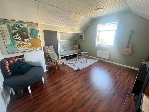 a living room with a couch and a guitar at Praktisk 3 roms leilighet in Bodø