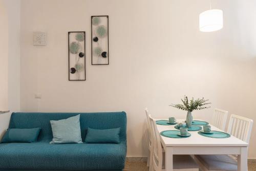 a living room with a blue couch and a table at Sea Lily in Lido di Ostia