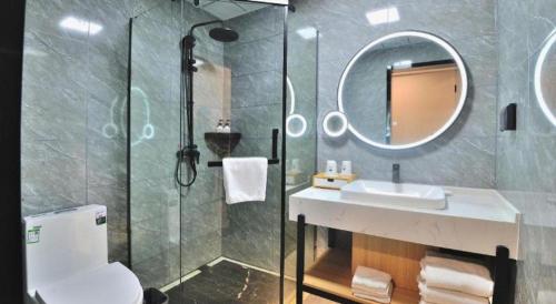 a bathroom with a shower and a sink and a mirror at GreenTree Inn Suzhou Shihu Suli Road Express Hotel in Suzhou