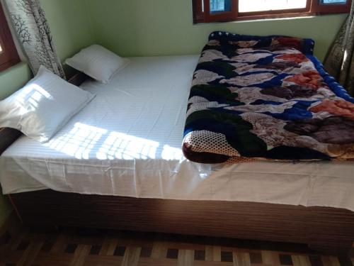 a bed with a quilt on it in a bedroom at Ejaa's House Bistro & Cafe in Rishīkesh