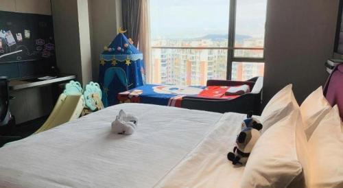 a bedroom with a bed with a stuffed animal on it at Hampton by Hilton Zhuhai Doumen in Zhuhai