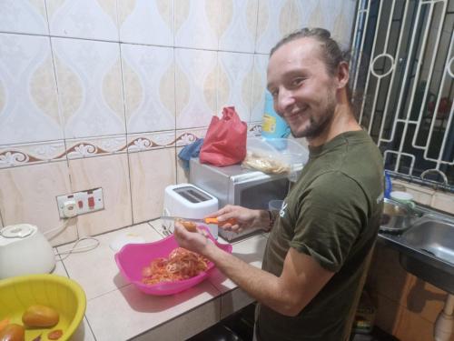 a man in a kitchen preparing food in a bowl at Msovi House in Arusha