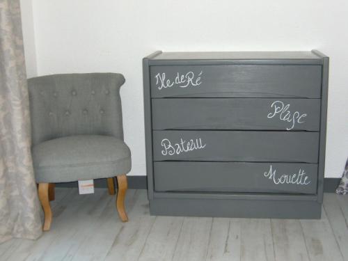 a dresser and a chair next to a dresser at Le Parasol in Ars-en-Ré