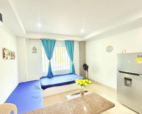 a small room with a blue bed and a refrigerator at Brisa del Mar in Cartagena de Indias
